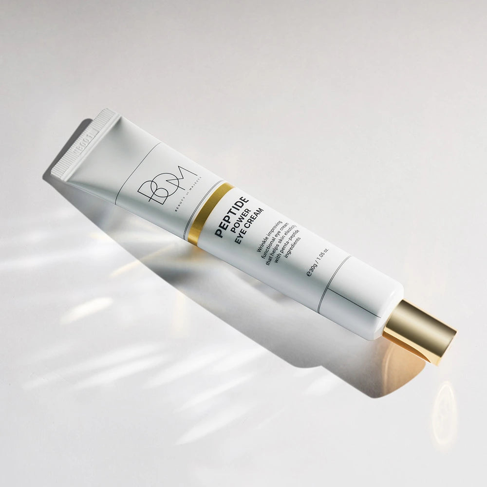 Tube de crème contour des yeux BOM Peptide Power sur fond gris clair
