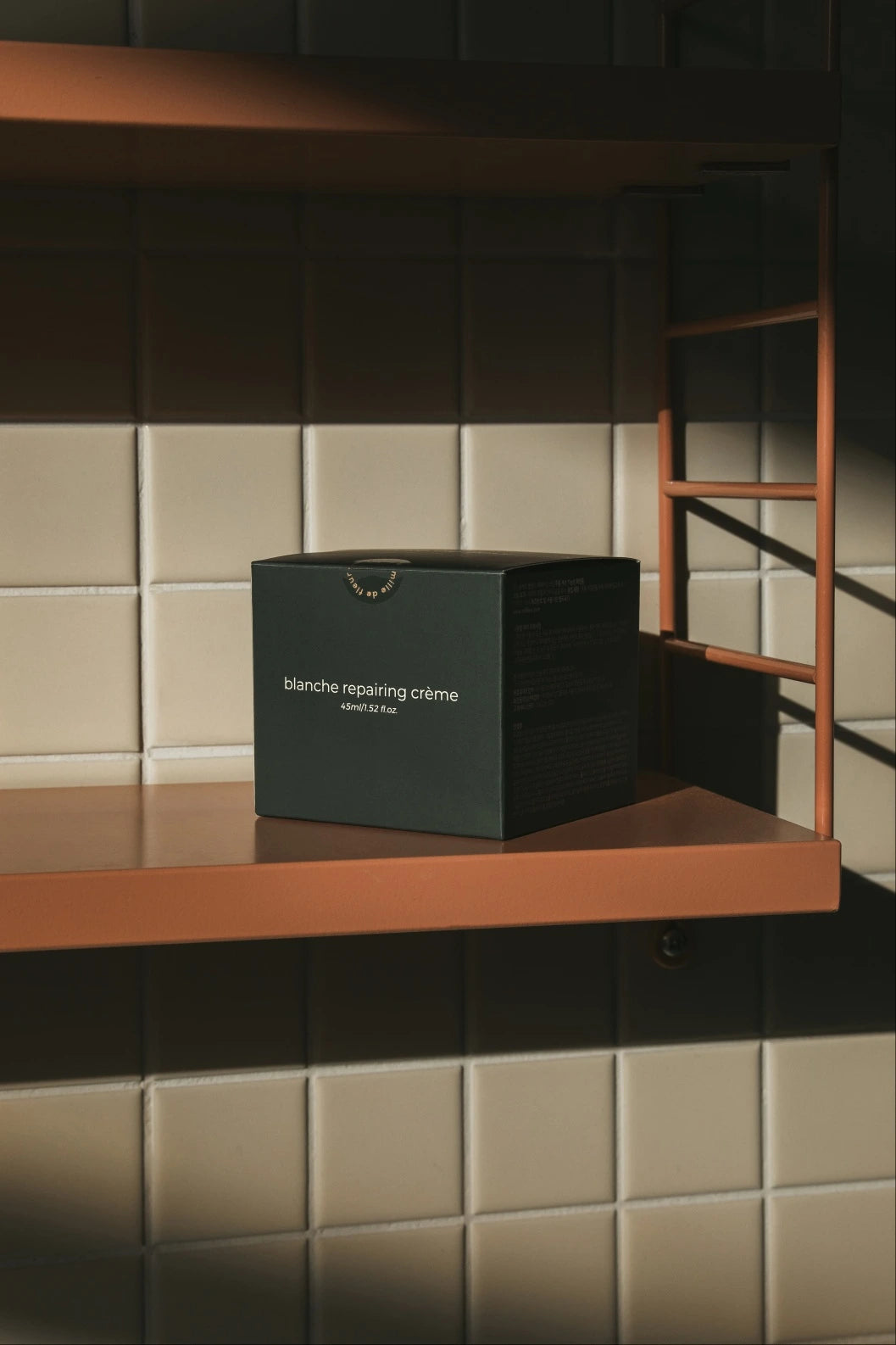 Mille de Fleur Blanche Repairing Crème green box on a shelf